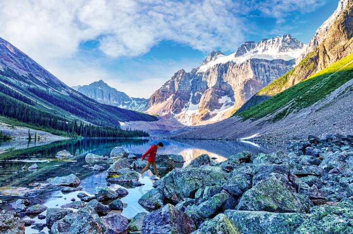 A vast, serene lake reflecting the tall, snow-capped Canadian Rocky Mountains